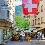 A red and white flag flying over a city street. Nutri-score in Switzerland