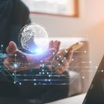 Technology Concept. A man holding virtual globe icon and mobile phone