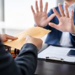 Businessman giving bribe money in the envelope to partner in a corruption scam in office. Ethical value at work