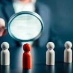 Magnifying success powerful red wooden businessman leading way. Identiying leader with potential concept