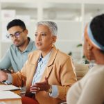 Senior, woman or business people in meeting with talking and giving strategy advice to the team for creative decision making.