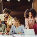 Diverse team of young Gen Z professionals collaborating on a project in a modern office