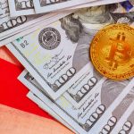 American dollars cash bills, gold Bitcoin token are arranged attractively on US flag fabric