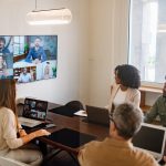 Business professionals actively discussing ideas and strategies during a hybrid corporate meeting.