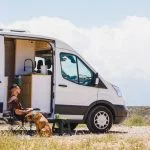 Man relaxing with dog in campervan at gorafe, spain