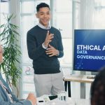 Man, presentation and screen with meeting for AI ethics, smile and planning for future web development at office. Person, speaker and staff in boardroom with data governance at startup tech agency