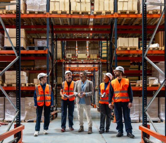 Logistics manager explaining and delegating operations to warehouse workers. Solve SMB Capacity Challenges