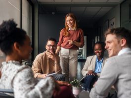 A group of motivated professionals sharing ideas, laughter, engagement, collaboration and collaboration in a bright office space, reflecting teamwork and creativity in a business environment.