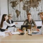 Young entrepreneurs in a modern office discussing Hong Kong company registration & digital strategies for modern startups.