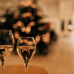 two glass of wine on a table in front of a Christmas tree